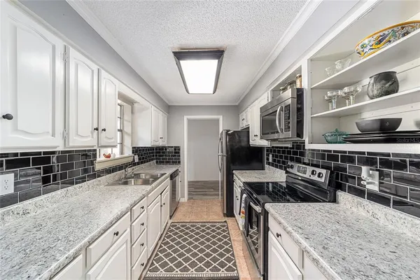 a kitchen with stainless steel appliances granite countertop a stove a sink and a refrigerator