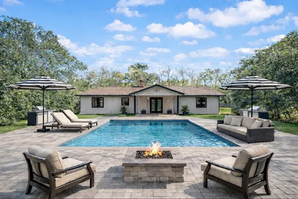 a view of a house with backyard and sitting area