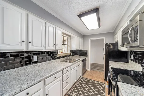 a kitchen with stainless steel appliances granite countertop a stove a sink and a microwave