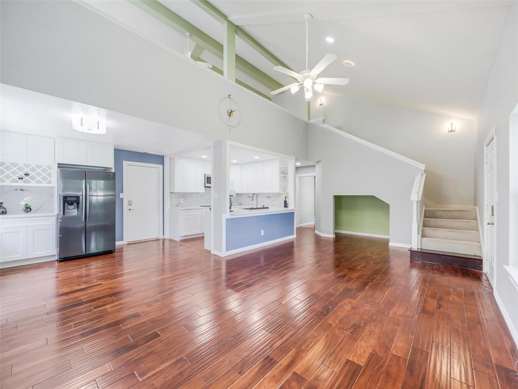 1716 East Parker Road Plano, TX 75074 - Photo 8 of 25 Spacious living area featuring rich wood-finish flooring, vaulted ceilings with exposed beams, a ceiling fan, and recessed lighting