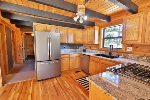 a kitchen with wooden floors and white appliances