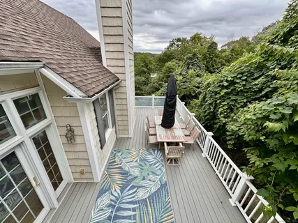 a roof deck with wooden floor and fence