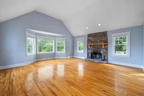 an empty room with floor to ceiling window and fireplace