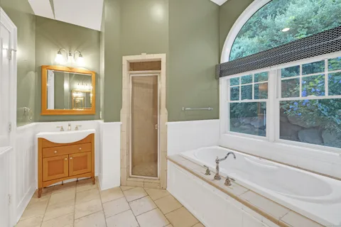 a bathroom with a granite countertop tub and a sink