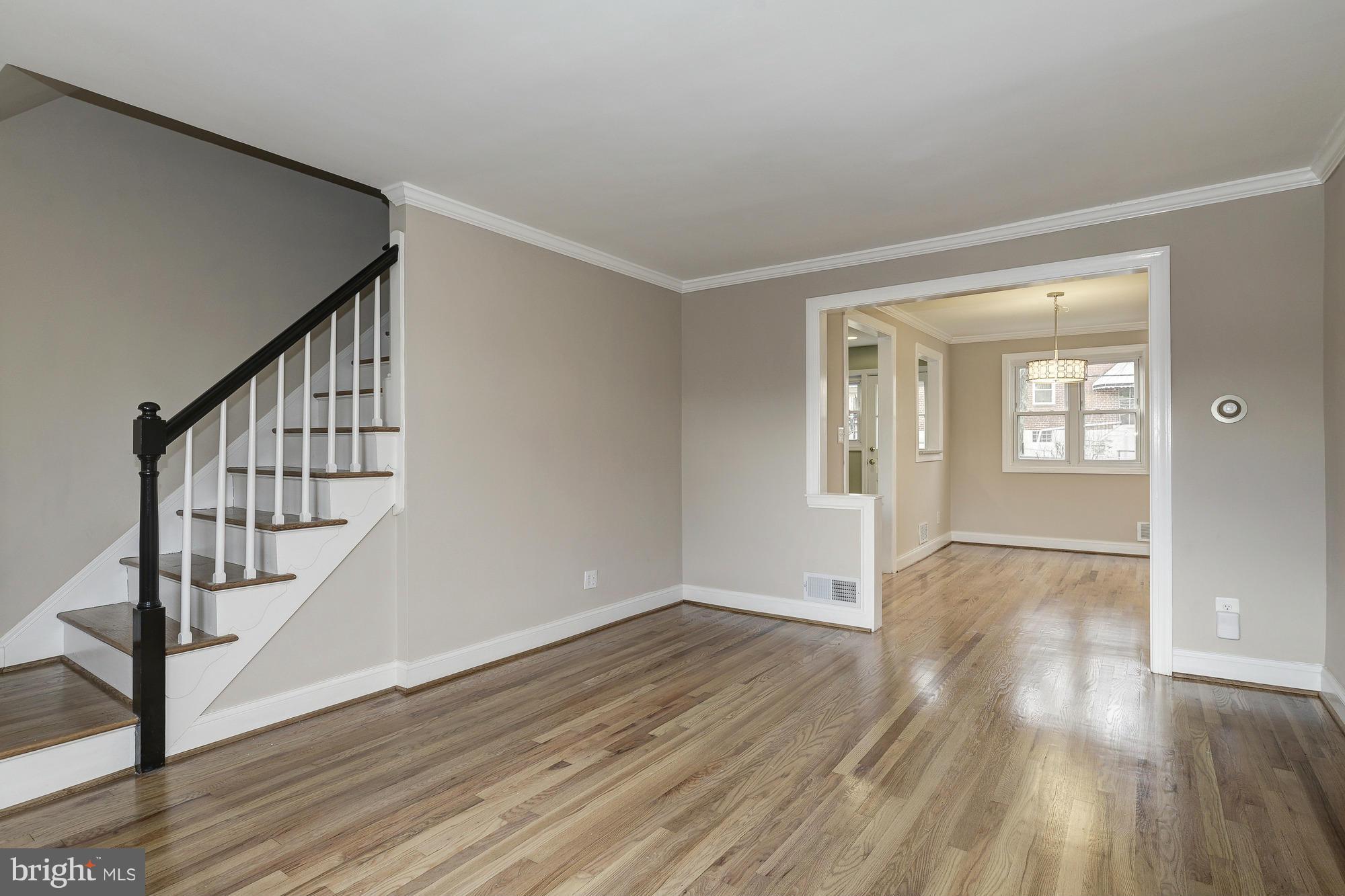 938 Coleridge Road Baltimore, MD 21229 - Photo 3 of 27 a view of an empty room with wooden floor and stairs