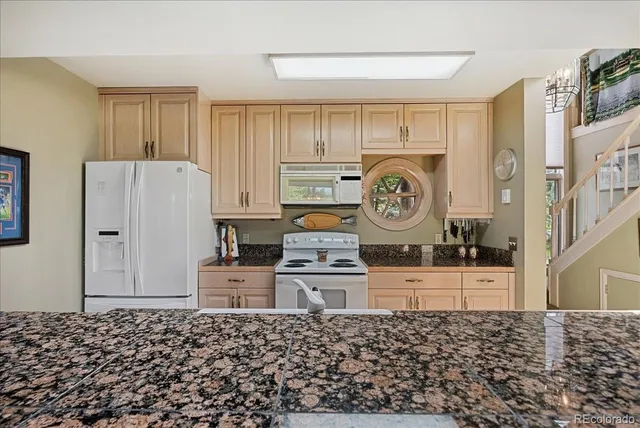 a living room with a stove a refrigerator and a cabinets