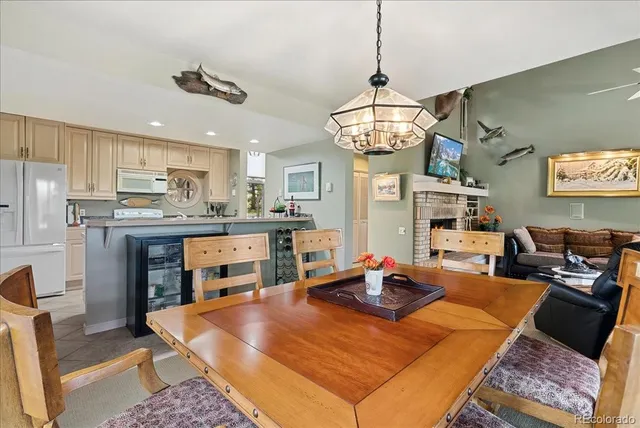 a room with stainless steel appliances kitchen island granite countertop furniture and a chandelier