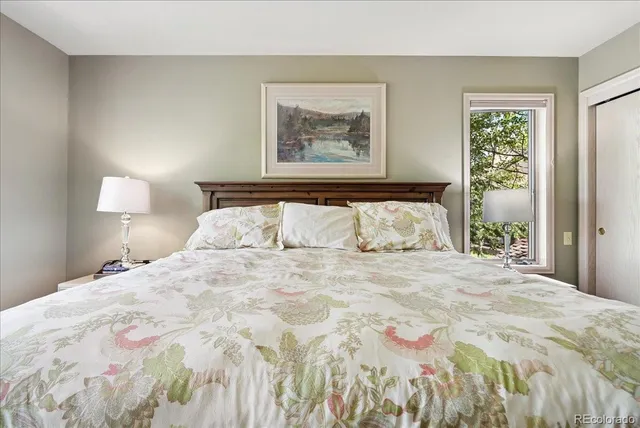 a bedroom with a bed and a painting on the wall