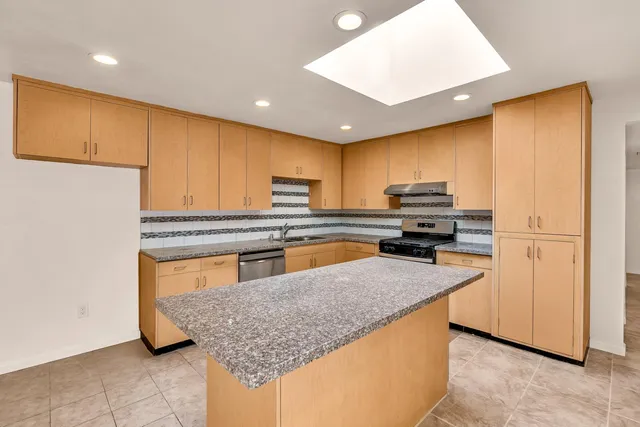 a kitchen with stainless steel appliances granite countertop a sink counter space cabinets and a window