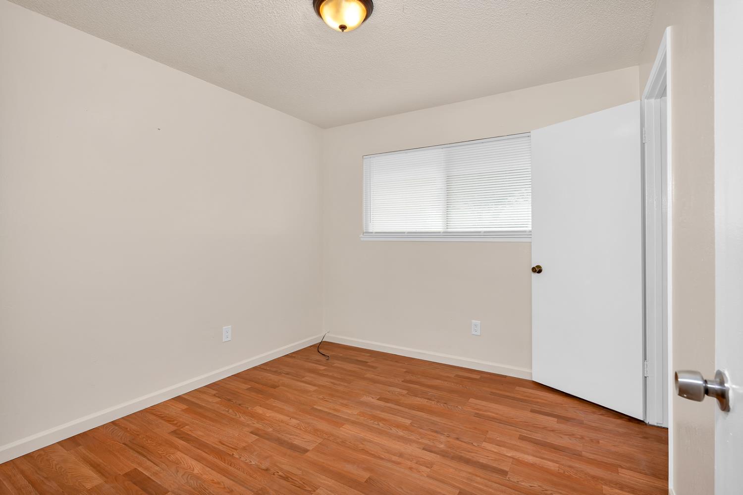 200 Dorita Way Modesto, CA 95354 - Photo 22 of 37 an empty room with wooden floor and windows