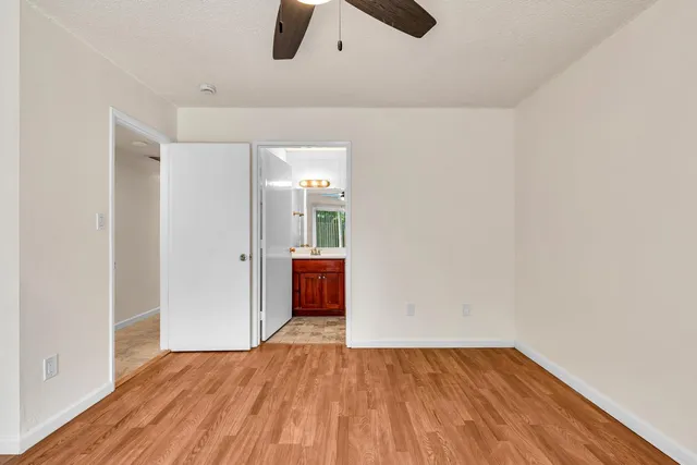 a view of a room with wooden floor and a ceiling fan
