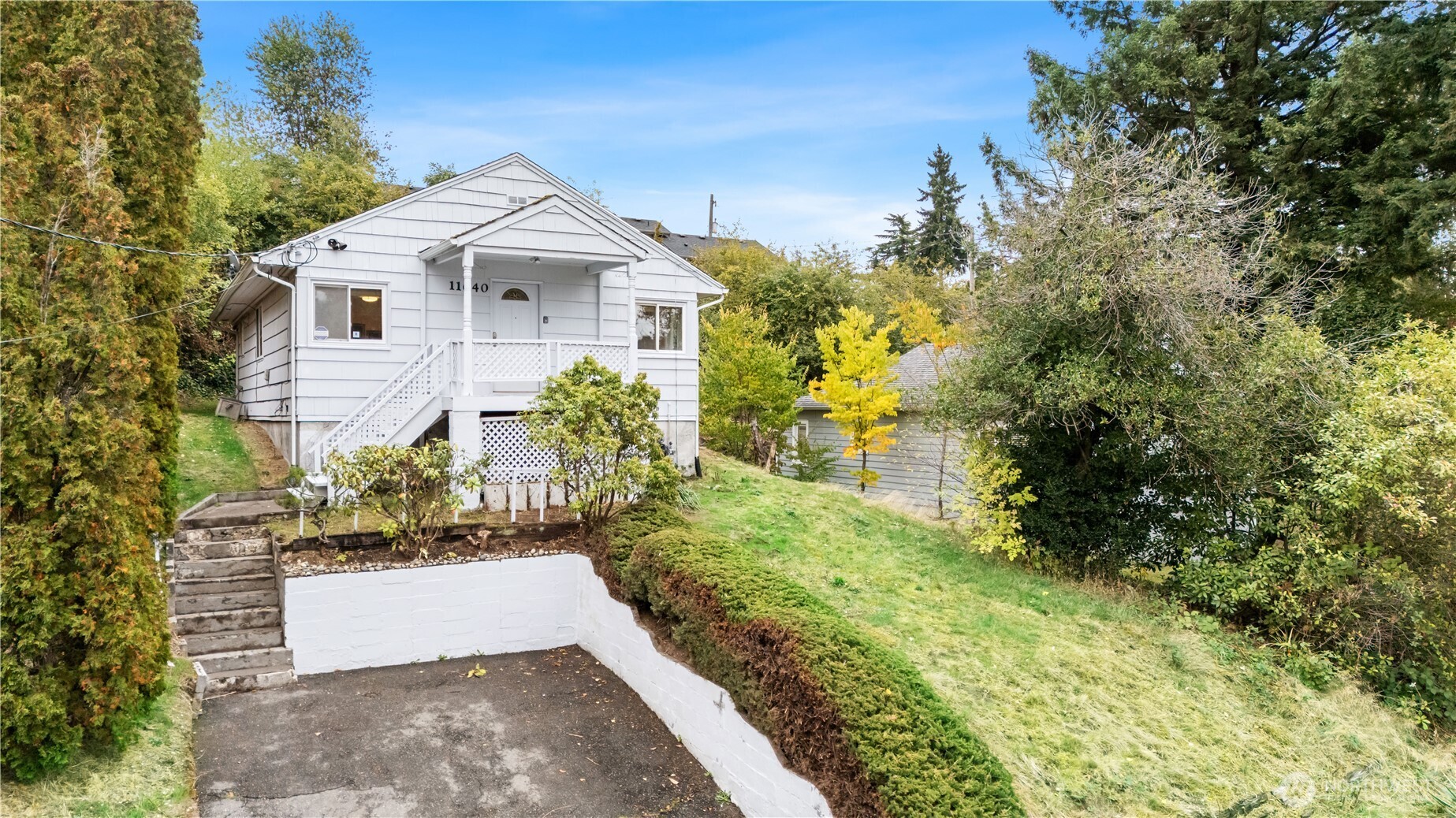 a view of a white house with a yard and plants