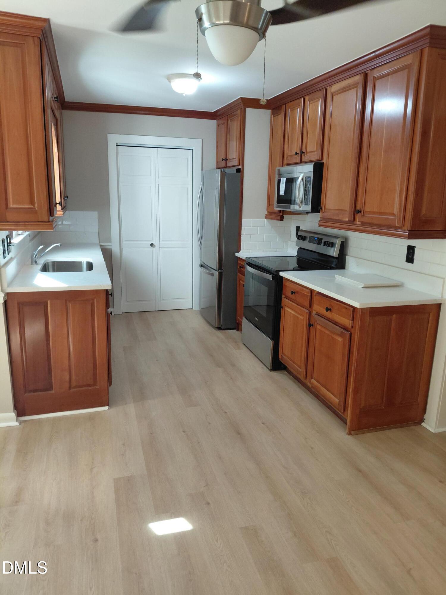 804 Olive Street Apex, NC 27502 - Photo 15 of 60 a kitchen with stainless steel appliances granite countertop a sink stove and cabinets