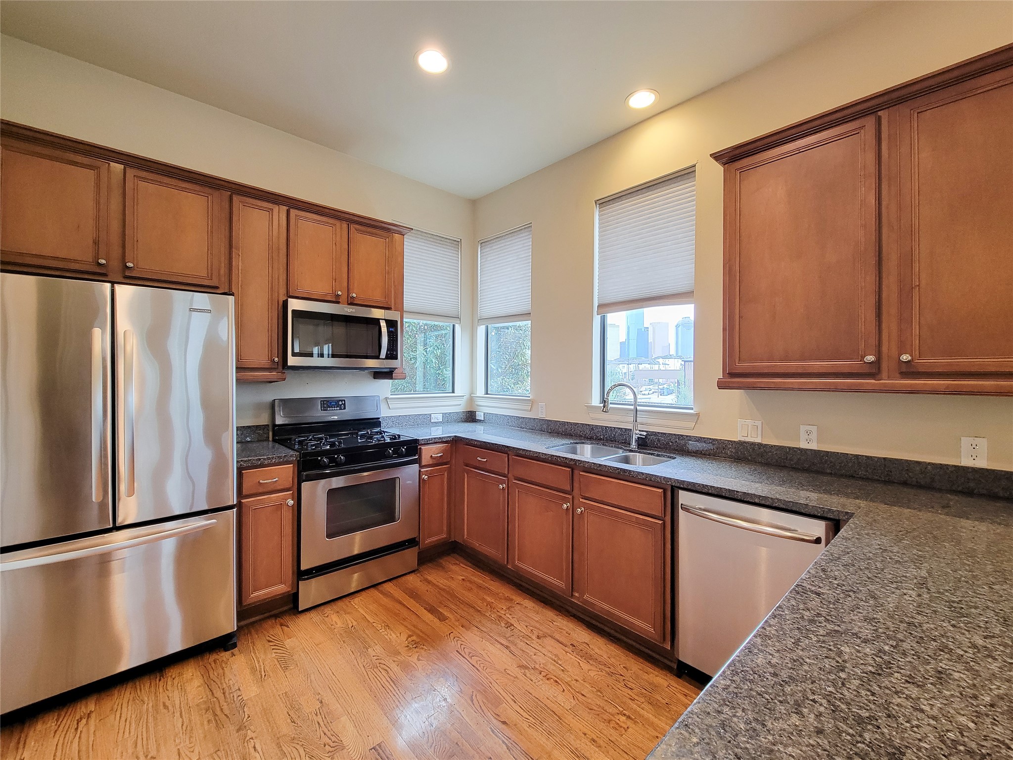 1602 White Street Houston, TX 77007 - Photo 19 of 41 a kitchen with stainless steel appliances granite countertop a refrigerator a sink dishwasher a stove top oven and a center island with wooden floor