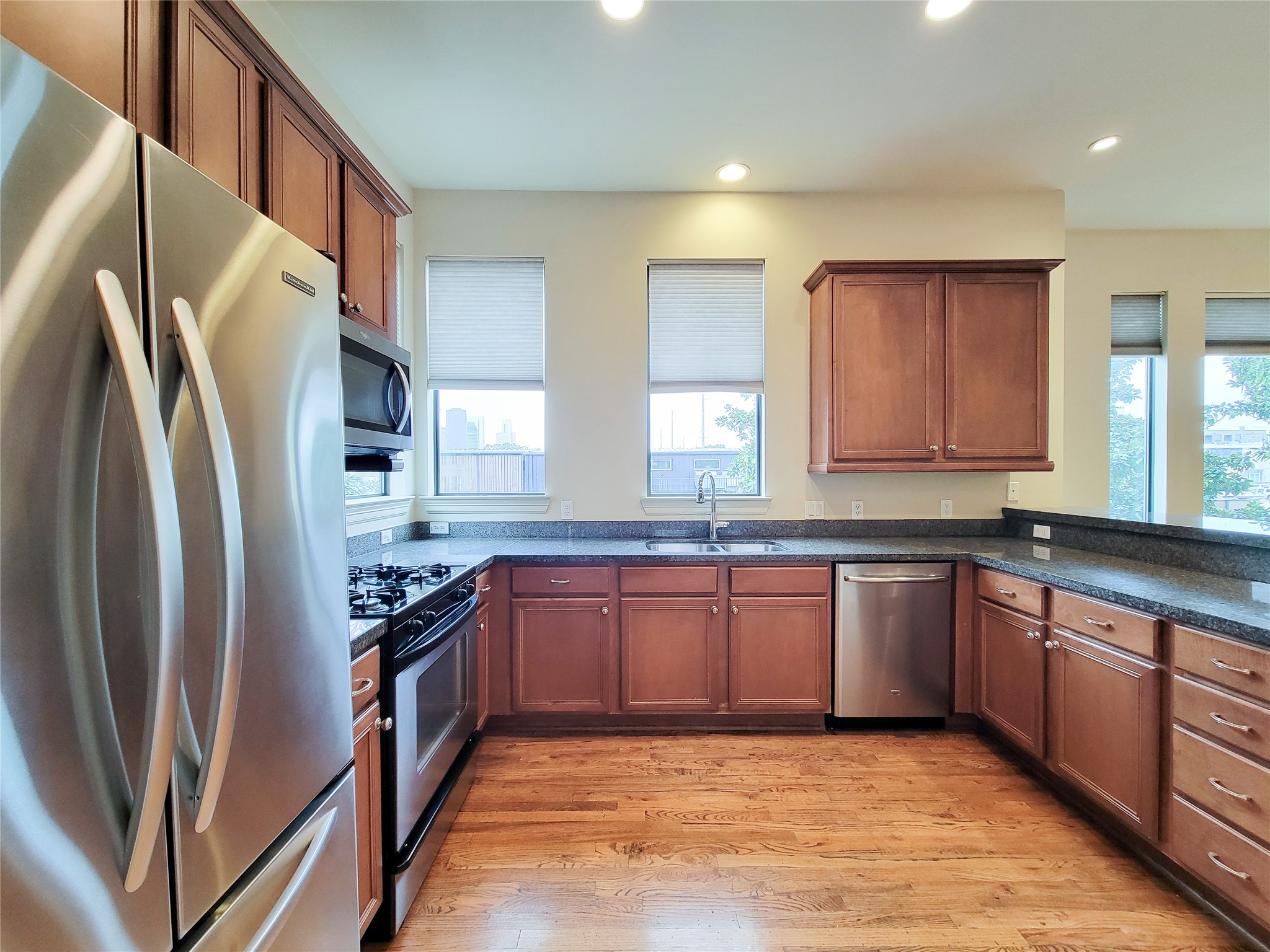 1602 White Street Houston, TX 77007 - Photo 20 of 41 a kitchen with stainless steel appliances granite countertop a refrigerator a sink dishwasher a stove with wooden cabinets and floor