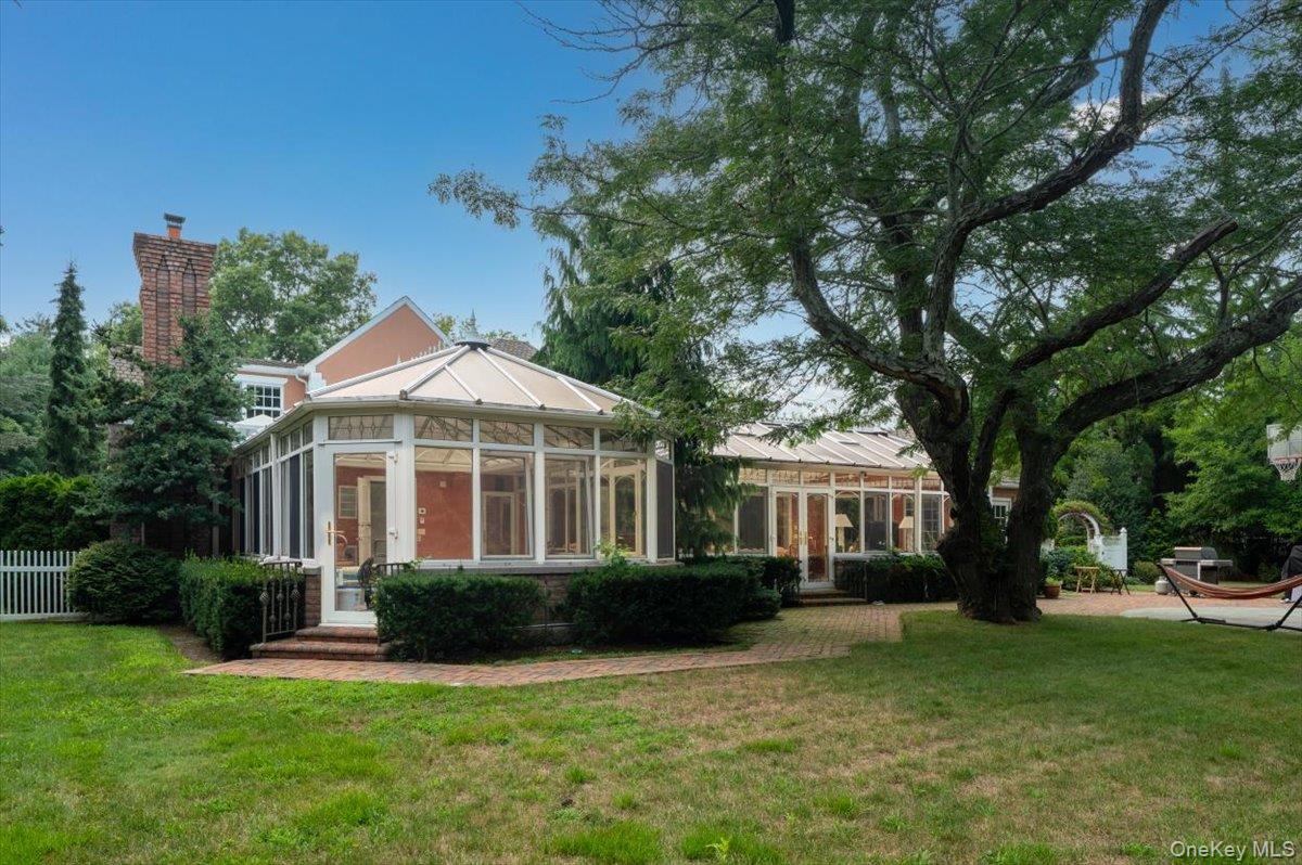 1331 Harbor Road Hewlett, NY 11557 - Photo 42 of 50 Rear view of house featuring a sunroom, a yard, and a chimney