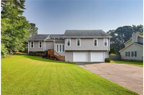 a front view of a house with yard and green space