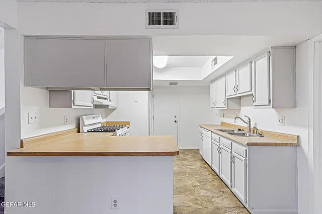 a kitchen with stainless steel appliances granite countertop a sink stove and cabinets