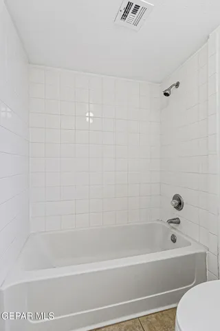 a bathroom with bathtub shower and toilet