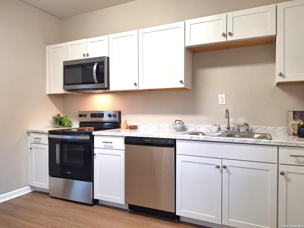 a kitchen with stainless steel appliances granite countertop a sink and a microwave