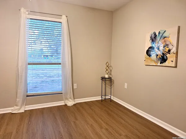 an empty room with wooden floor and window