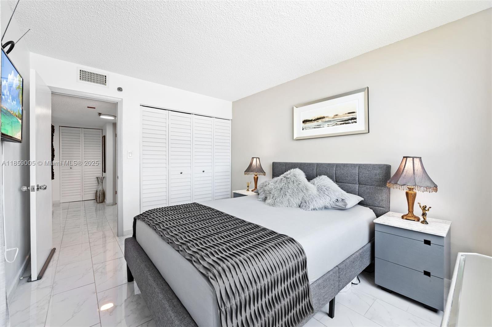 17890 West Dixie Highway, Unit 603 Miami, FL 33160 - Photo 17 of 34 a bedroom with a bed and a lamp on dresser