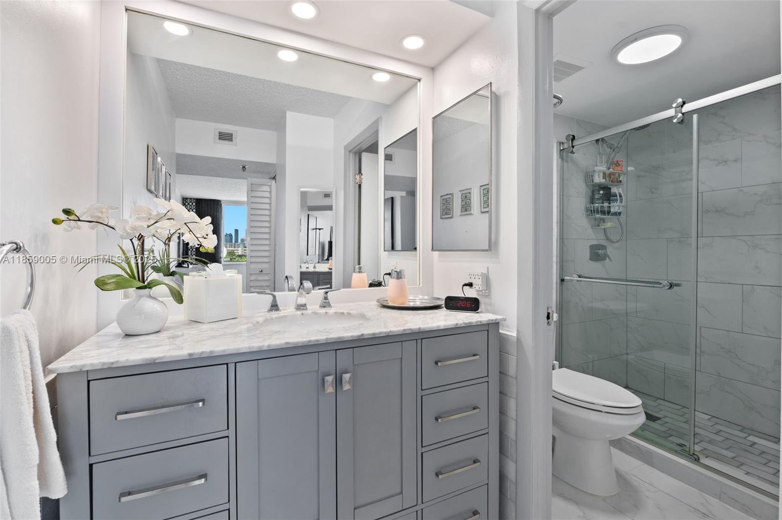 17890 West Dixie Highway, Unit 603 Miami, FL 33160 - Photo 19 of 34 a bathroom with a granite countertop sink a toilet and a shower