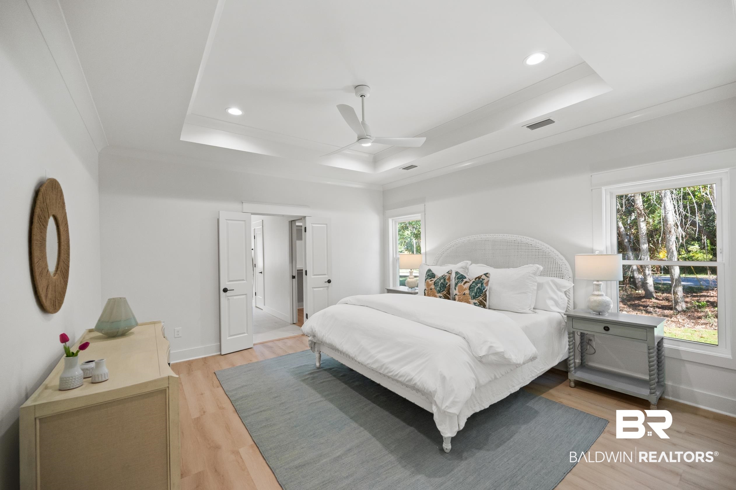28889 Canal Road Orange Beach, AL 36561 - Photo 34 of 55 Bedroom featuring a tray ceiling, ceiling fan, ornamental molding, and light wood-type flooring