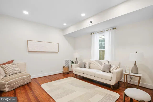 a living room with furniture and a wooden floor