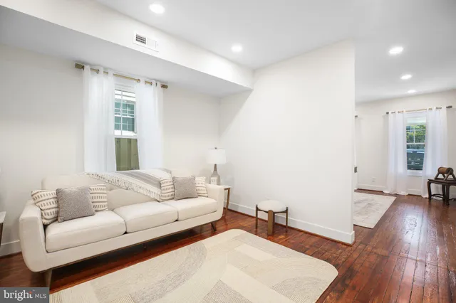 a living room with furniture and a wooden floor