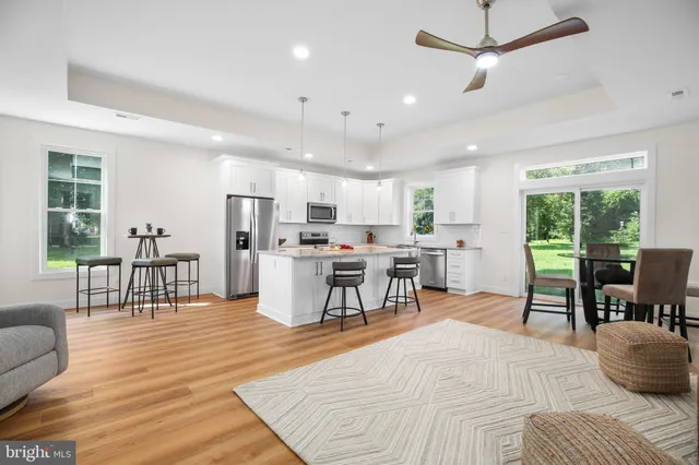 a living room with stainless steel appliances kitchen island granite countertop furniture and a dining table