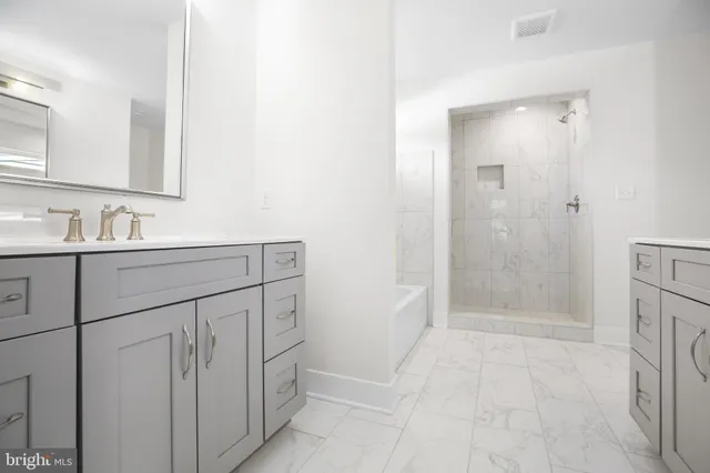 a bathroom with a double vanity sink a mirror and shower