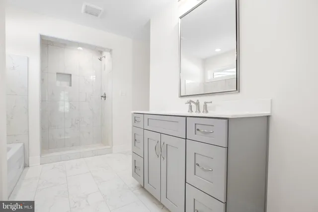 a bathroom with a shower sink and mirror