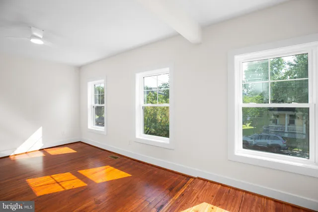 a view of a room with wooden floor and windows