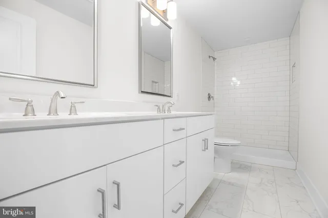 a bathroom with a sink toilet and mirror