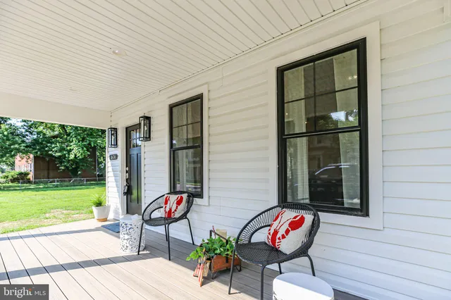 a roof deck with a table and chairs and potted plants