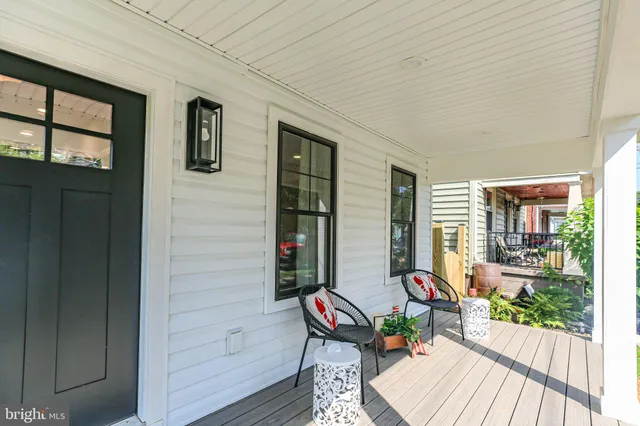 a balcony with wooden floor and outdoor seating