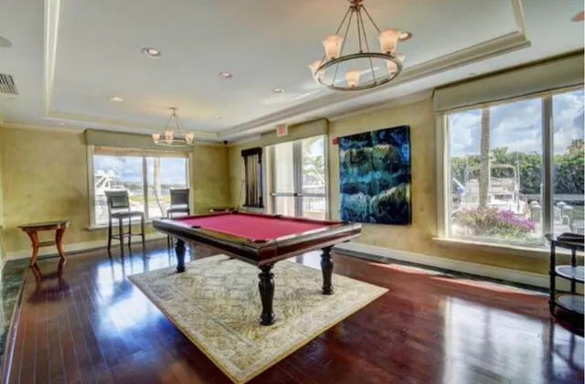 a room with pool table wooden floor and windows