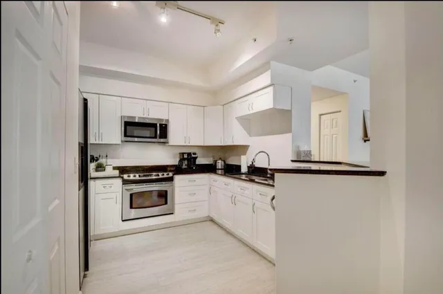 a kitchen with white cabinets and white appliances