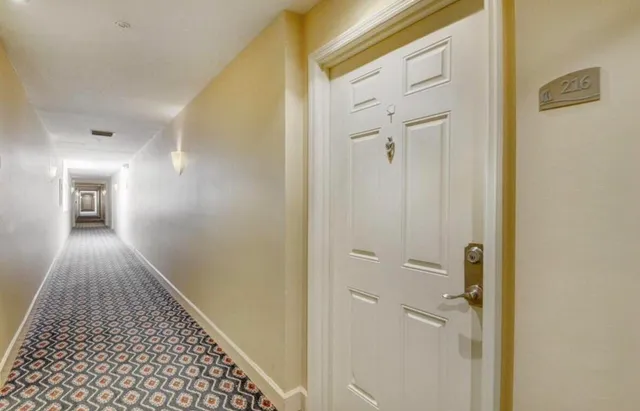 a view of a hallway with wooden floor and closet