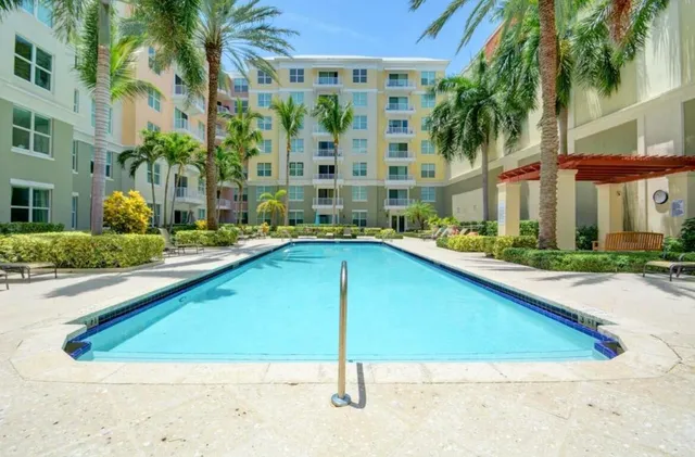 a view of swimming pool with outdoor seating and house in the background