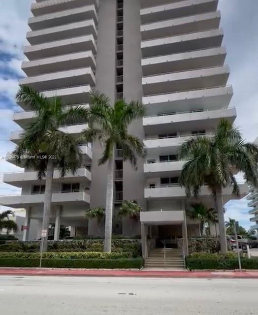 9225 Collins Avenue, Unit 1407 Surfside, FL 33154 - Photo 3 of 7 a front view of a multi story building with yard and parking