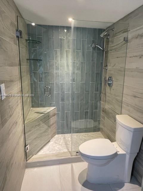 9225 Collins Avenue, Unit 1407 Surfside, FL 33154 - Photo 5 of 7 a bathroom with a shower and a toilet
