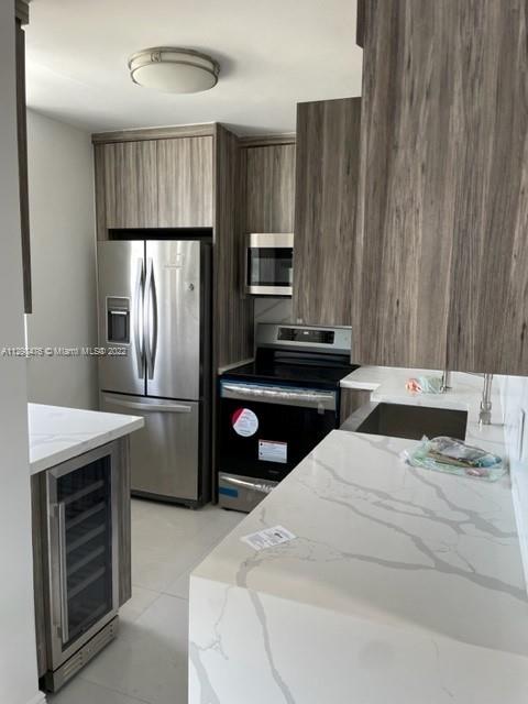 9225 Collins Avenue, Unit 1407 Surfside, FL 33154 - Photo 7 of 7 a kitchen with kitchen island a counter space a sink appliances and cabinets