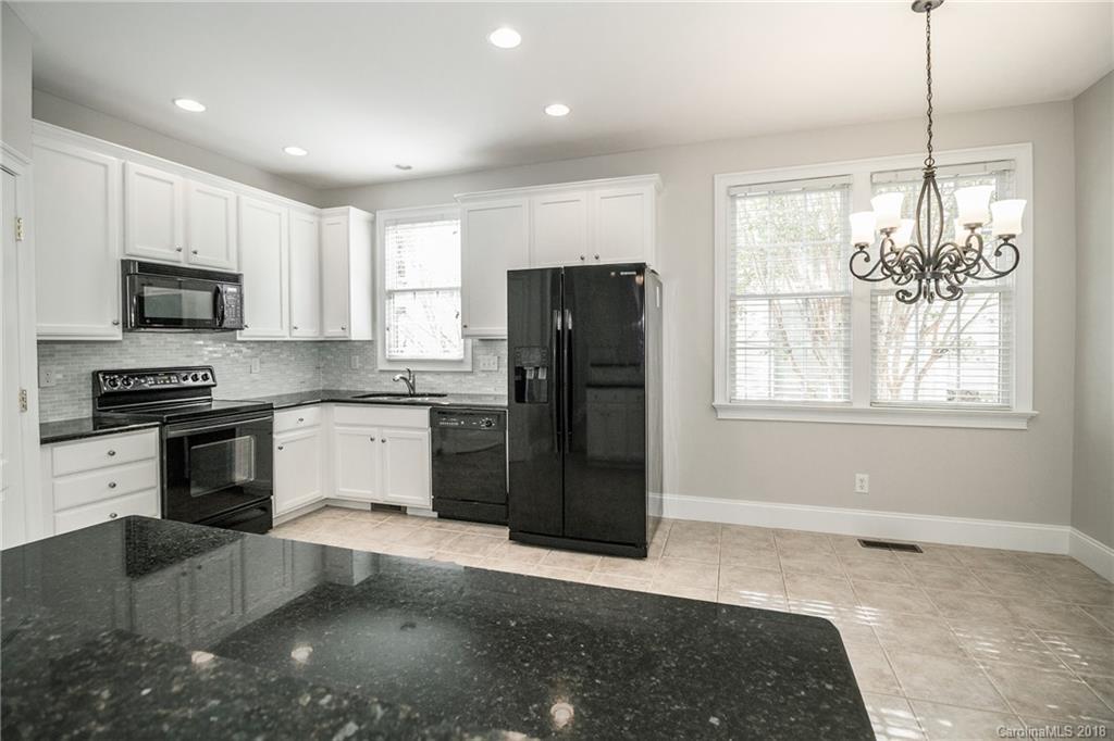 1376 Barnett Woods Fort Mill, SC 29708 - Photo 22 of 34 a kitchen with granite countertop stainless steel appliances a refrigerator cabinets and microwave