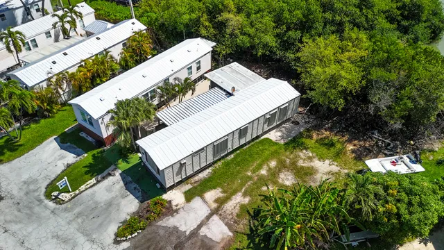 an aerial view of a house with swimming pool and large trees