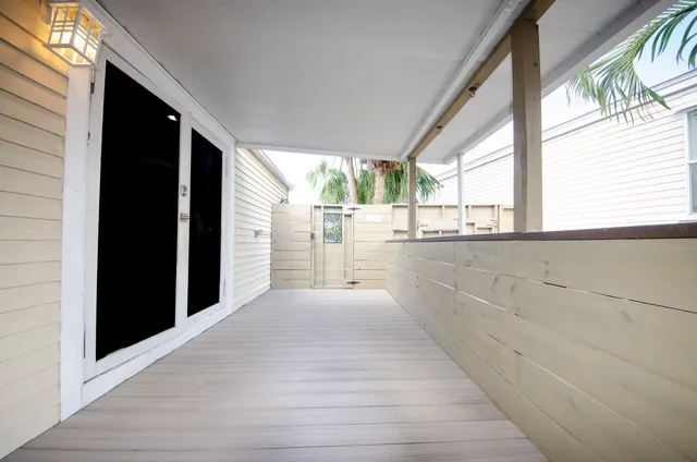 a view of a porch with wooden floor and a hallway