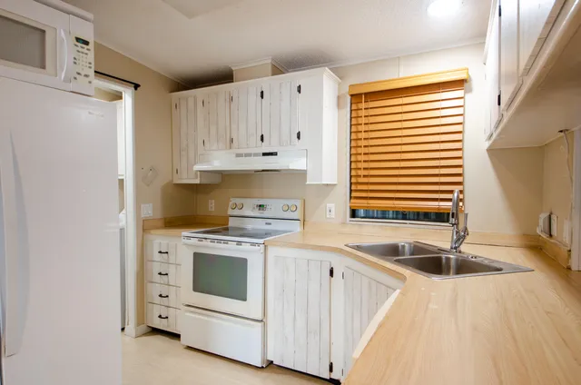 a kitchen with white cabinets and white appliances