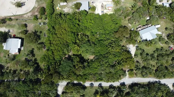 an aerial view of residential house with outdoor space and trees all around