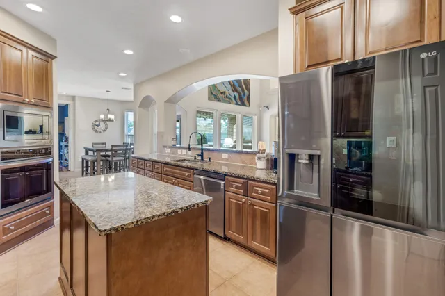a kitchen with stainless steel appliances granite countertop a stove top oven a sink and dishwasher